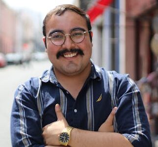A cheerful man smiling on a vibrant urban street, exuding confidence.